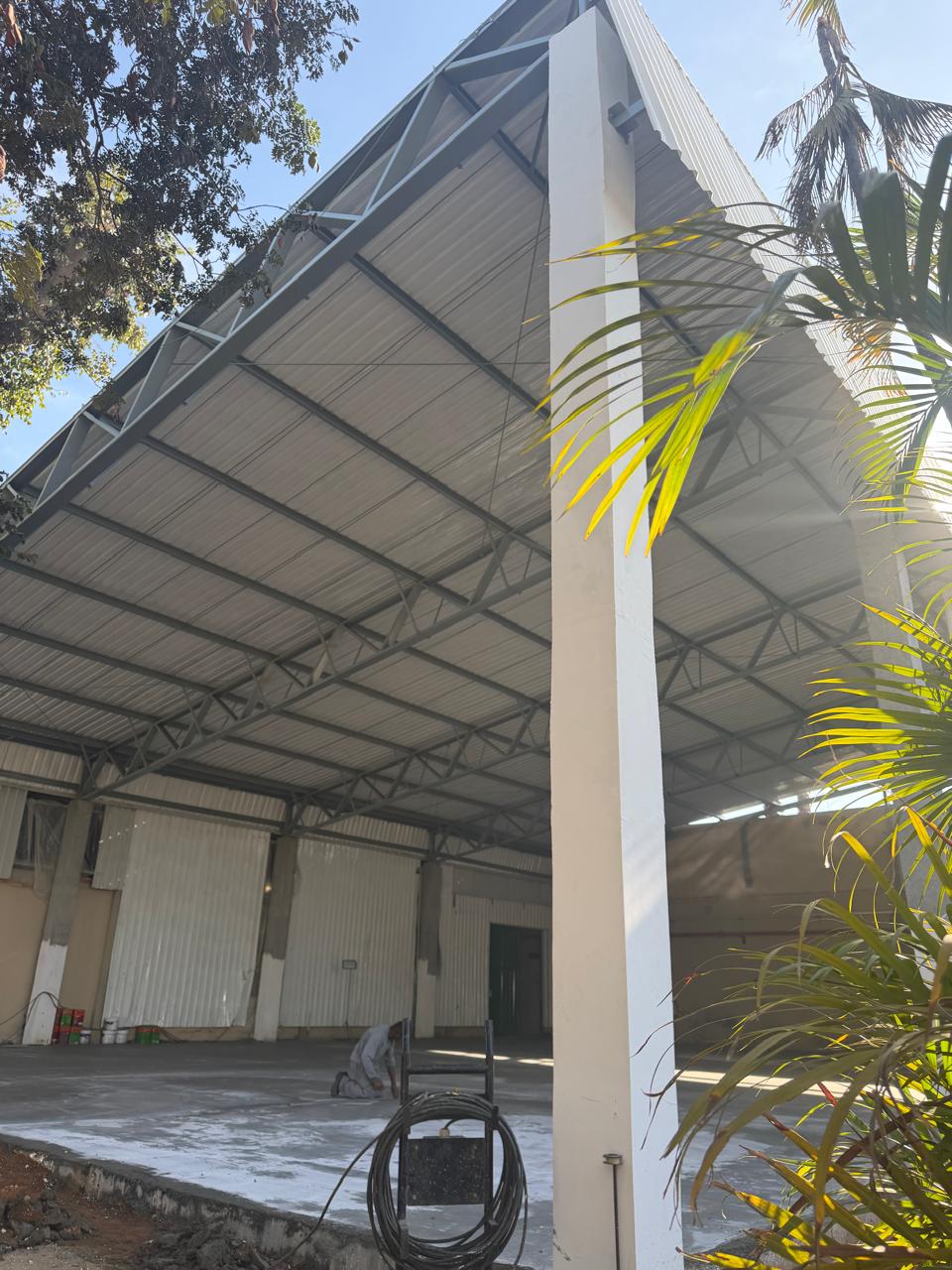 Montagem de galpão industrial com treliças de cobertura.